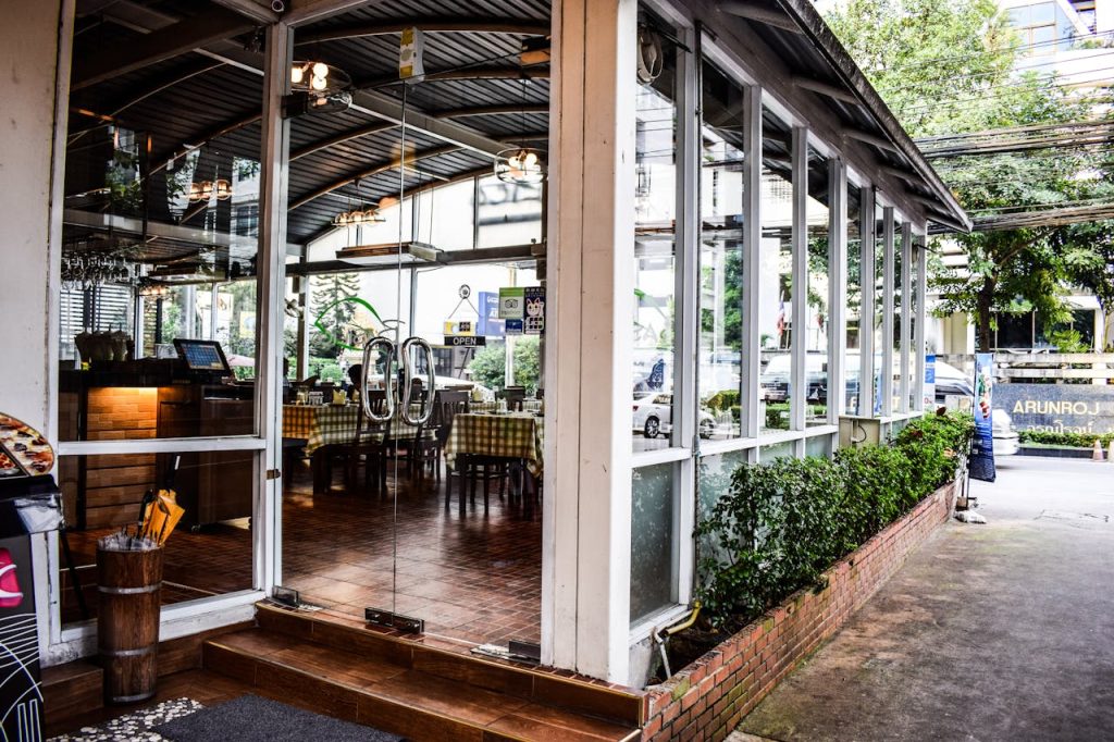 Modern restaurant with large glass windows and entrance, featuring contemporary interior design.